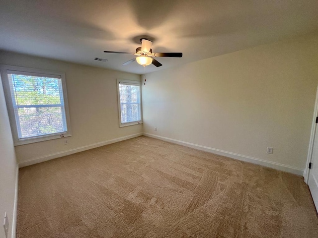 carpeted spare room with ceiling fan