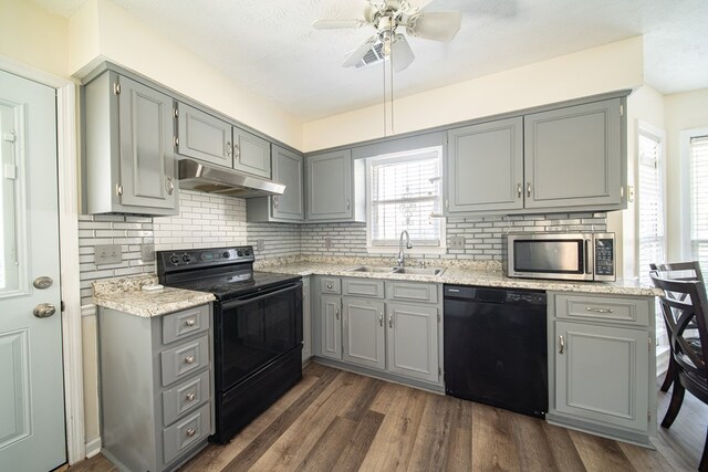 kitchen with sink, dark wood-type flooring, a healthy amount of sunlight, and black appliances