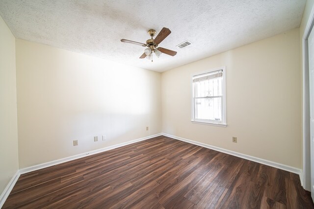 spare room featuring ceiling fan, dark hardwood / wood-style flooring, and a textured ceiling