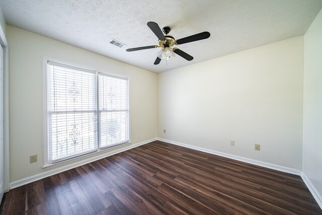 empty room with ceiling fan, dark hardwood / wood-style flooring, and a textured ceiling