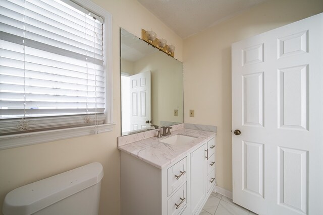 bathroom with a wealth of natural light, vanity, and toilet