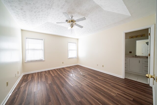 spare room with a textured ceiling, dark hardwood / wood-style flooring, ceiling fan, and sink