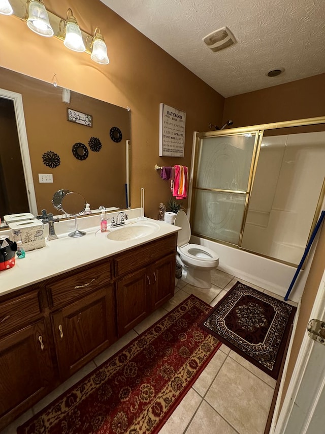 full bathroom featuring combined bath / shower with glass door, a textured ceiling, tile patterned floors, and toilet