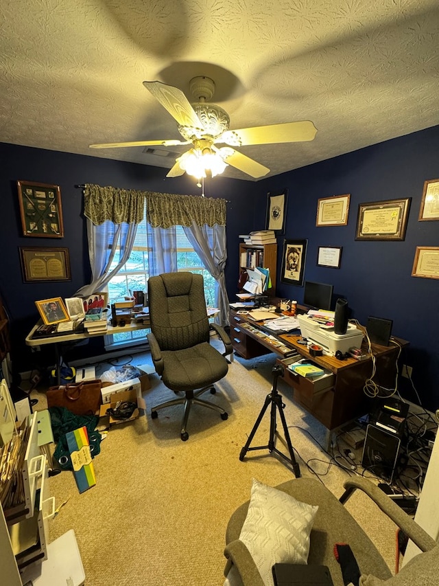 home office with a textured ceiling, carpet floors, and ceiling fan