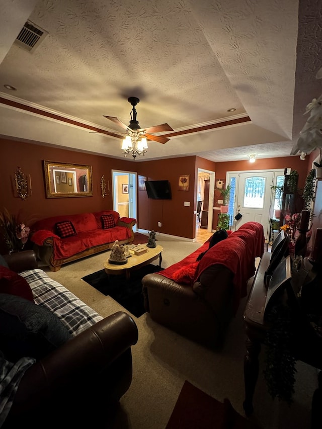 living room featuring a textured ceiling, carpet floors, a tray ceiling, and ceiling fan