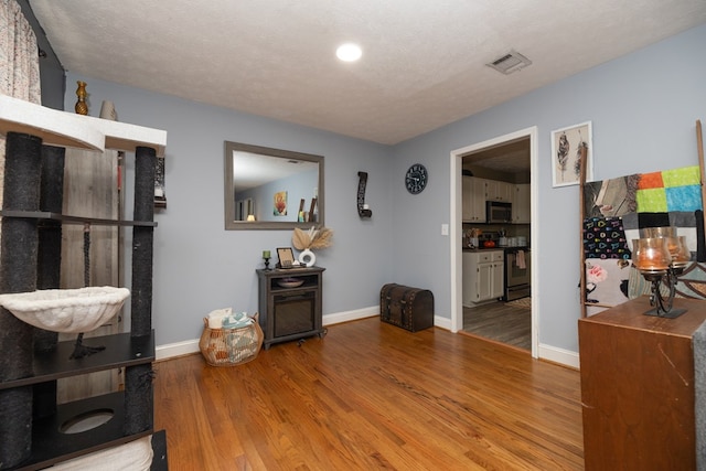 interior space with baseboards, visible vents, and wood finished floors