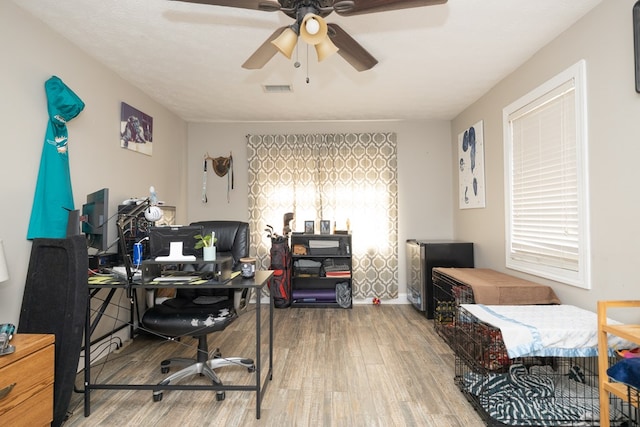 office featuring wood finished floors, visible vents, and a ceiling fan