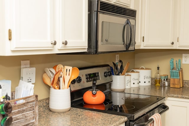 kitchen featuring light stone countertops, white cabinetry, and stainless steel electric stove