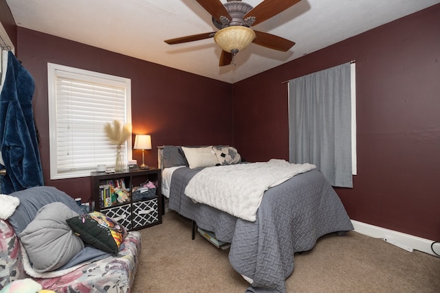 bedroom featuring light carpet, ceiling fan, and baseboards