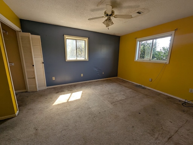 spare room featuring ceiling fan, a textured ceiling, baseboards, and carpet floors