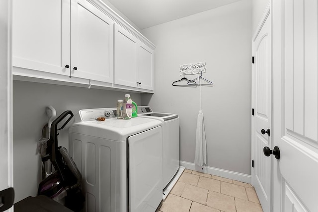 laundry room featuring cabinet space, light tile patterned floors, baseboards, and separate washer and dryer