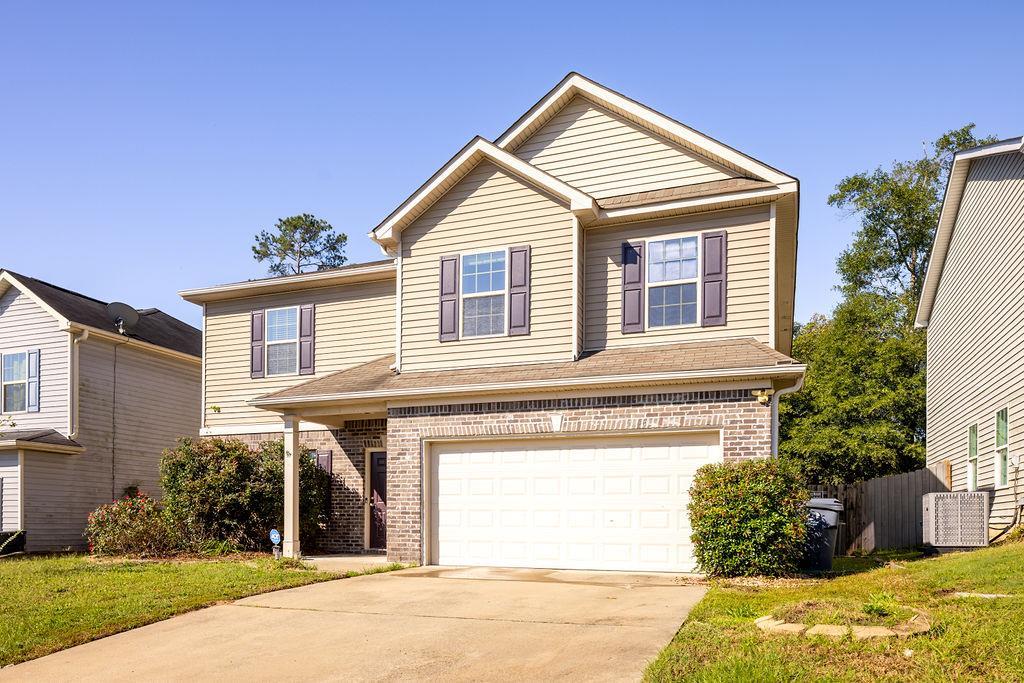 view of front property featuring a garage and a front yard