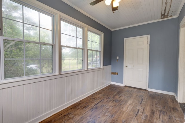 empty room with ornamental molding, ceiling fan, dark wood-style floors, and baseboards