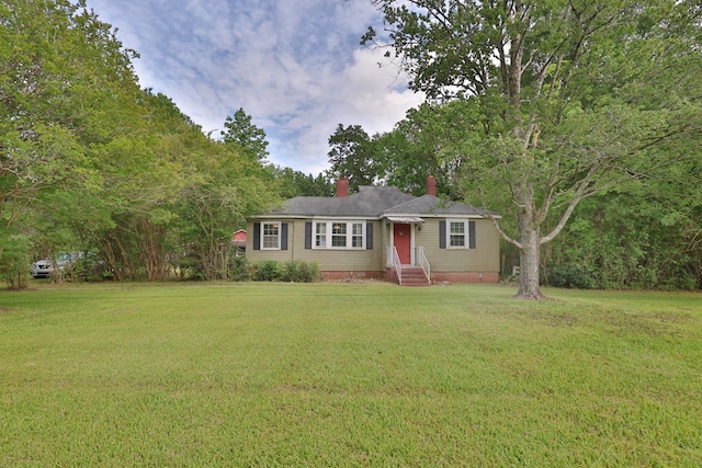 ranch-style house featuring a chimney and a front yard