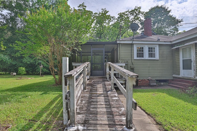deck with a sunroom, entry steps, and a yard