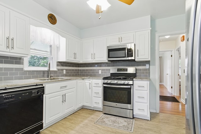 2608 5th Ave, Phenix City, AL 36867 - kitchen featuring appliances with stainless steel finishes, a sink, white cabinets, and light wood finished floors