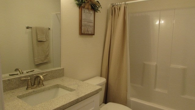 full bathroom featuring shower / tub combo with curtain, vanity, and toilet