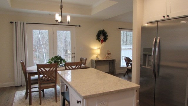 dining space featuring ornamental molding, wood-type flooring, and a raised ceiling