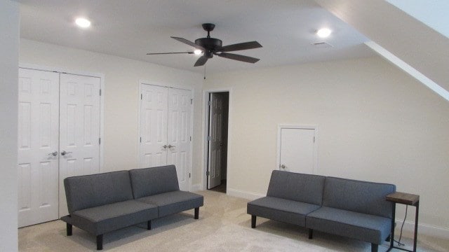 sitting room with ceiling fan and light colored carpet