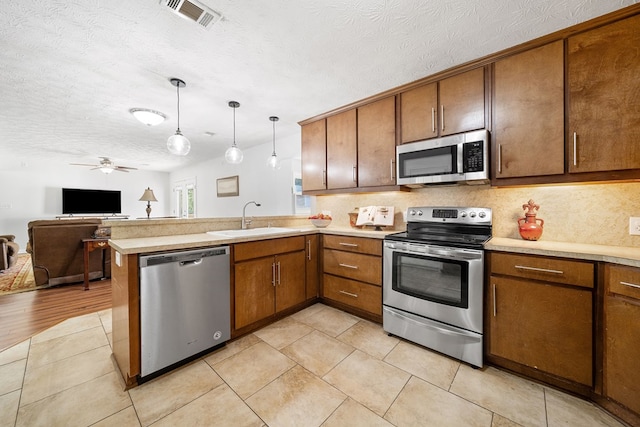 3796 Auburn Rd, Phenix City, AL 36870 - kitchen with appliances with stainless steel finishes, open floor plan, light countertops, a peninsula, and hanging light fixtures