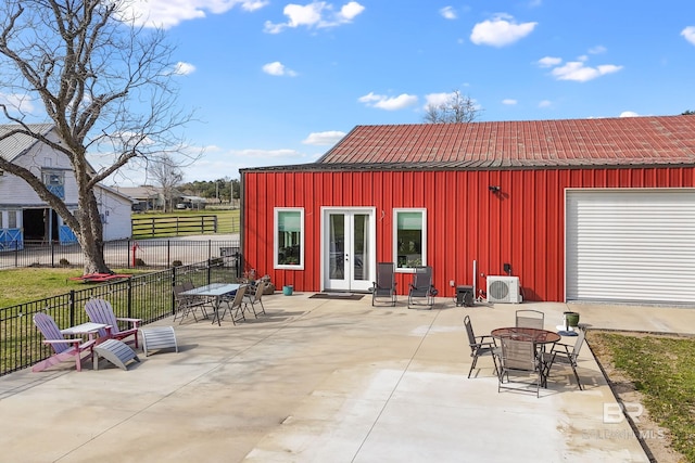 view of patio with ac unit, an outdoor fire pit, fence, and french doors