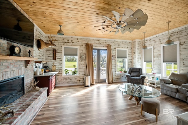 living area featuring a brick fireplace, wood ceiling, plenty of natural light, and wood finished floors