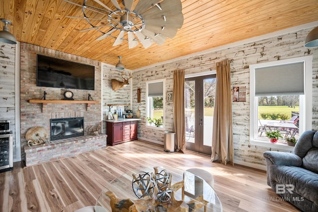 living area featuring light wood-type flooring, a brick fireplace, wood ceiling, and french doors