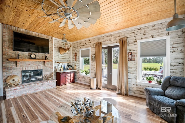 living room featuring light wood-type flooring, wooden ceiling, a healthy amount of sunlight, and a fireplace