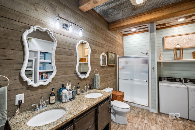 full bathroom featuring a sink, a shower stall, beam ceiling, and washer and dryer