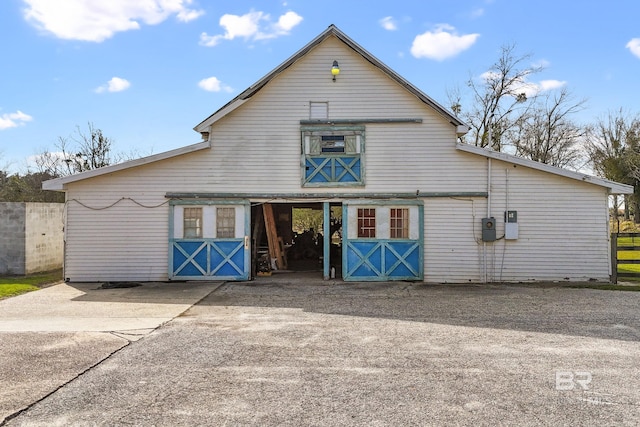 rear view of property featuring an outdoor structure and a barn