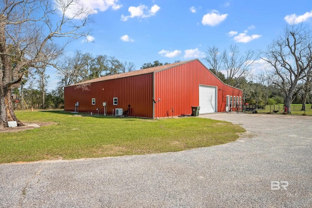 view of pole building with cooling unit, gravel driveway, a yard, and fence