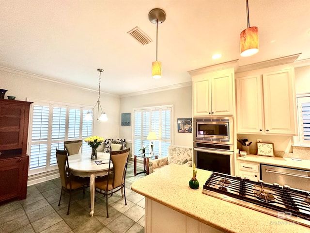 kitchen featuring light stone counters, pendant lighting, stainless steel appliances, and ornamental molding