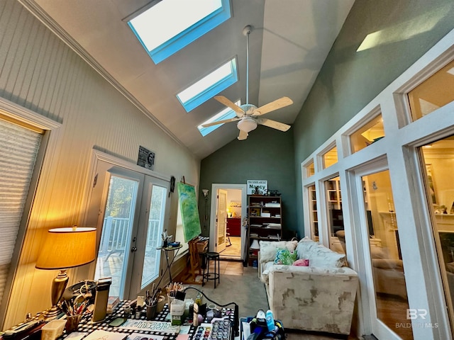 living room with high vaulted ceiling, ceiling fan, a skylight, and french doors