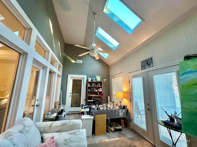 office space with a wealth of natural light, high vaulted ceiling, a skylight, ceiling fan, and french doors