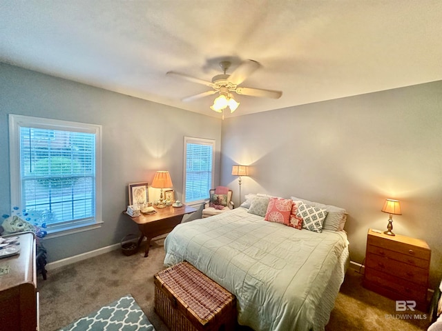 bedroom featuring ceiling fan, dark carpet, and multiple windows