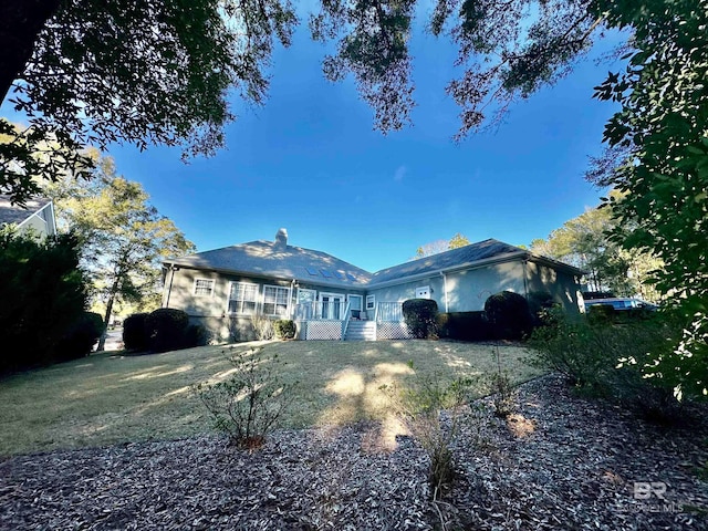 back of house with a lawn and a deck