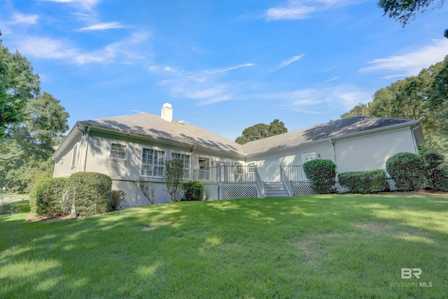 rear view of property with a lawn and a deck