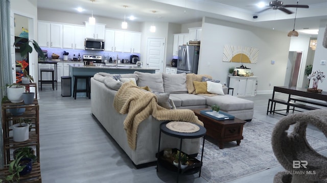 living room featuring light hardwood / wood-style floors and ceiling fan