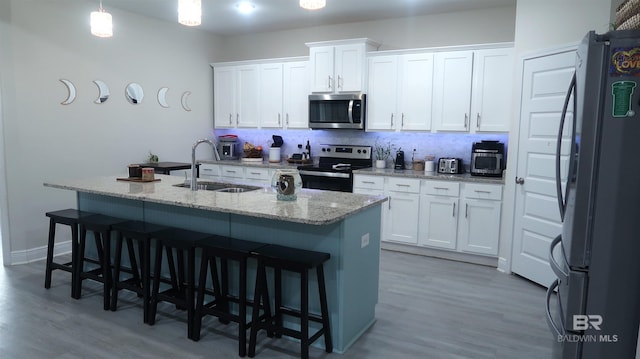 kitchen featuring pendant lighting, stainless steel appliances, white cabinetry, and sink