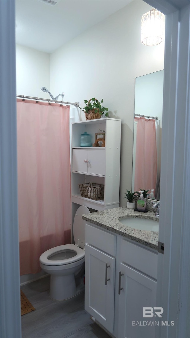 full bathroom featuring vanity, toilet, wood-type flooring, and shower / tub combo