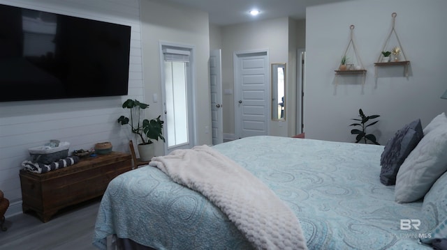 bedroom with multiple windows and hardwood / wood-style floors