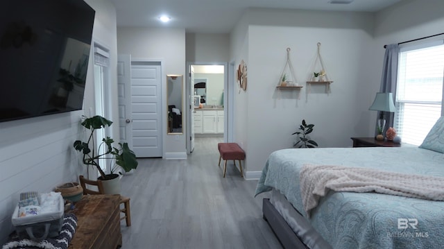 bedroom with wood-type flooring and ensuite bath