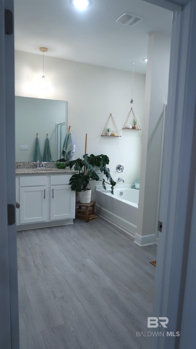 bathroom with vanity, a bathtub, and wood-type flooring