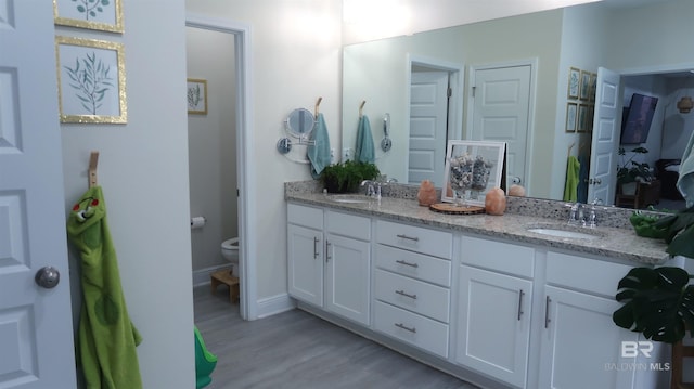 bathroom with hardwood / wood-style flooring, vanity, and toilet