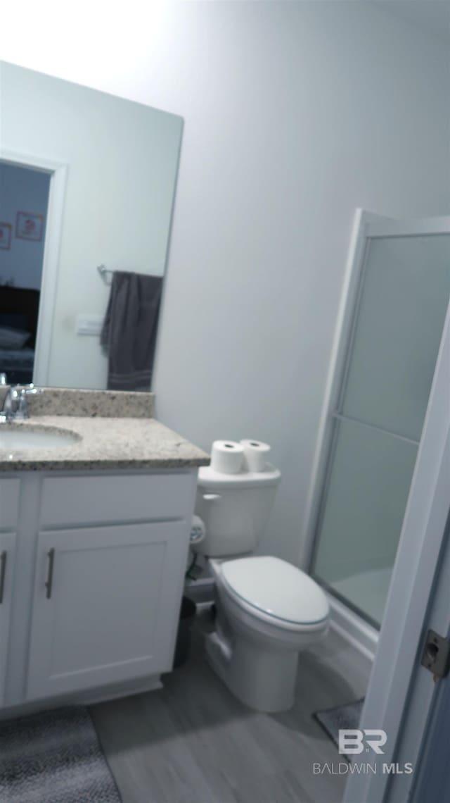 bathroom with vanity, toilet, and an enclosed shower