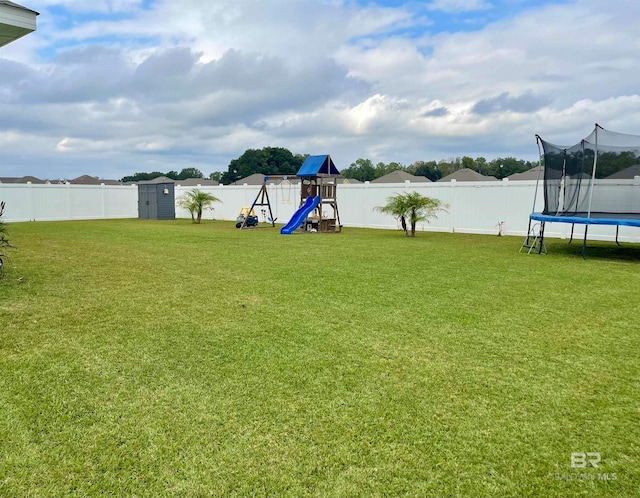 view of yard with a playground, a trampoline, and a storage unit