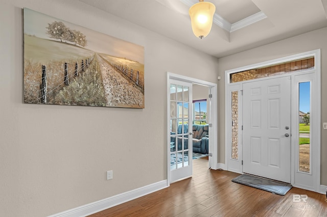 entryway featuring ornamental molding and dark hardwood / wood-style flooring