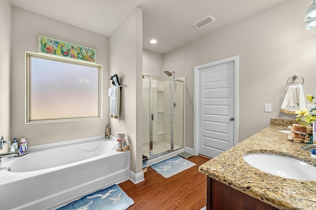 bathroom with hardwood / wood-style flooring, shower with separate bathtub, and vanity