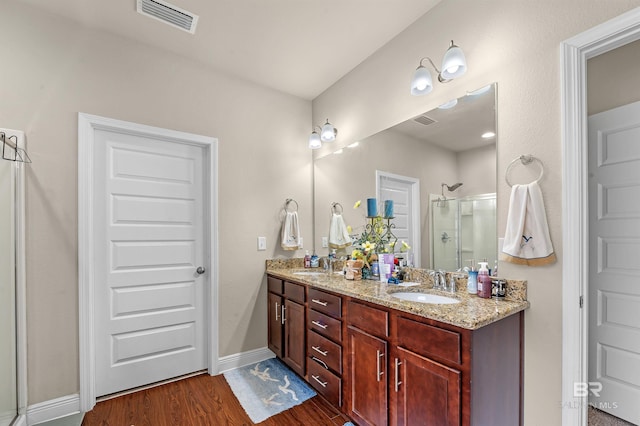 bathroom with walk in shower, hardwood / wood-style flooring, and vanity