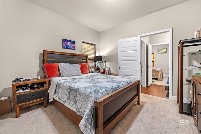 bedroom with vaulted ceiling and light hardwood / wood-style floors